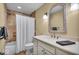 Bathroom with tiled shower and tub, decorative mirror, and updated sink at 7316 Lesley Ave, Indianapolis, IN 46250