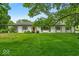 Charming ranch-style home featuring a well-manicured lawn and a welcoming red front door at 7316 Lesley Ave, Indianapolis, IN 46250