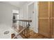 Upstairs hallway with hardwood floors, wood banister, and multiple bedroom doorways at 7334 Country Brook Dr, Indianapolis, IN 46260