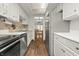 Spacious kitchen featuring stainless steel appliances, white cabinets, and a view of the dining room at 7334 Country Brook Dr, Indianapolis, IN 46260