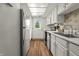 Bright kitchen with stainless steel appliances, white cabinets, and a door that leads to the backyard at 7334 Country Brook Dr, Indianapolis, IN 46260