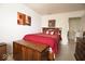 Comfortable bedroom featuring a red comforter set, wood chest and decorative art pieces at 7737 Wolfgang Pl, Indianapolis, IN 46239