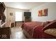 A bedroom with a red bedspread and comforter on a low profile bed with a window and dark wood furniture at 7737 Wolfgang Pl, Indianapolis, IN 46239