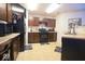 A kitchen with dark brown cabinets, black appliances, tile flooring and a black refrigerator at 7737 Wolfgang Pl, Indianapolis, IN 46239