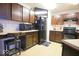Kitchen with dark brown cabinets, black appliances, tile flooring and a black refrigerator with a TV on top at 7737 Wolfgang Pl, Indianapolis, IN 46239