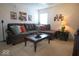 A living room with a large sectional couch, glass top coffee table, and artwork on the walls at 7737 Wolfgang Pl, Indianapolis, IN 46239