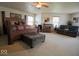 Spacious main bedroom with a king bed, dark wood furniture, sitting area and multiple windows at 7737 Wolfgang Pl, Indianapolis, IN 46239