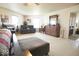 Spacious main bedroom with a king bed, dark wood furniture, sitting area and multiple windows at 7737 Wolfgang Pl, Indianapolis, IN 46239