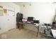 Home office setup with a multi-tiered shelving unit, dual computer setup, and neutral carpeting at 7737 Wolfgang Pl, Indianapolis, IN 46239