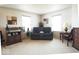 Cozy sitting area featuring a dark leather sofa, vintage stereo equipment, and natural light from two windows at 7737 Wolfgang Pl, Indianapolis, IN 46239