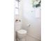 Well-lit powder room with fresh white fixtures, floral decor and window, adding a touch of elegance at 8317 Pine Branch Ln, Indianapolis, IN 46234