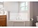Bright bathroom features a soaking tub under a window and wood cabinets with counter space at 8317 Pine Branch Ln, Indianapolis, IN 46234