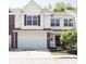 Charming two-story townhome featuring a spacious garage and a welcoming front entrance with beautiful landscaping at 8317 Pine Branch Ln, Indianapolis, IN 46234