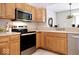 The kitchen has wood cabinets, stainless steel appliances, and a window to the dining area at 8317 Pine Branch Ln, Indianapolis, IN 46234