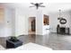 Open concept living room with grey flooring, ceiling fan, bar seating and view to kitchen at 8317 Pine Branch Ln, Indianapolis, IN 46234
