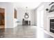 Open-concept living room with a fireplace, seamless access to the kitchen, and wood-look flooring enhancing the space's appeal at 8317 Pine Branch Ln, Indianapolis, IN 46234