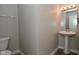 A half bathroom features a pedestal sink, mirror with lighting, and a toilet at 8354 Fieldfare Way, Indianapolis, IN 46237