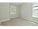 A bedroom features neutral carpeting, two windows, and neutral paint at 8354 Fieldfare Way, Indianapolis, IN 46237