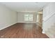 A sunlit living room with wood-look floors and a staircase to the upper level at 8354 Fieldfare Way, Indianapolis, IN 46237
