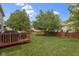 View of the backyard featuring a deck, grill, and spacious green lawn at 8430 Harrison Pkwy, Fishers, IN 46038