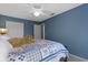Blue walled bedroom featuring a ceiling fan, white trim, and plush bedding with a decorative throw at 8430 Harrison Pkwy, Fishers, IN 46038