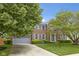 Beautiful brick home featuring a manicured lawn, mature trees, and a two-car garage for curb appeal at 8430 Harrison Pkwy, Fishers, IN 46038