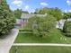 Charming brick two-story home with a well-manicured front lawn and a mature tree enhancing its curb appeal at 8430 Harrison Pkwy, Fishers, IN 46038