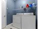 Functional laundry room with washer, dryer, storage shelf, and door to adjoining room at 8430 Harrison Pkwy, Fishers, IN 46038