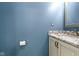 Stylish powder room with blue walls, decorative granite countertop, and neutral-colored vanity at 8430 Harrison Pkwy, Fishers, IN 46038