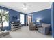 Bright sitting room featuring blue walls, natural light, and patterned furniture at 8430 Harrison Pkwy, Fishers, IN 46038