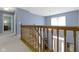 Carpeted staircase with wood railing leading to a bright, naturally lit entryway at 8430 Harrison Pkwy, Fishers, IN 46038