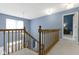 Carpeted staircase with wooden railing leading to a bright, naturally lit entryway at 8430 Harrison Pkwy, Fishers, IN 46038