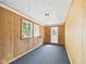 Cozy bonus room featuring wood paneling, carpet, a window, and a door to the exterior at 903 W 22Nd St, Anderson, IN 46016