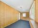 Bonus room featuring wood paneling, carpet, white ceilings, and a door to the exterior at 903 W 22Nd St, Anderson, IN 46016