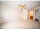 Spacious bedroom with neutral carpet, ceiling fan, and view to bath area at 931 Wickham Ct # 101, Carmel, IN 46032