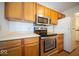 Galley kitchen featuring stainless steel appliances and wood cabinetry at 931 Wickham Ct # 101, Carmel, IN 46032