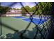 View of the outdoor tennis court, surrounded by a fence and greenery, perfect for sports and recreation at 931 Wickham Ct # 101, Carmel, IN 46032