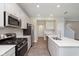 Well-lit kitchen with stainless steel appliances, white cabinets, gas range, and hardwood floors at 9570 Beckett St, Avon, IN 46123
