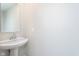New powder room with pedestal sink, modern faucet, and wall mirror at 9604 Beckett St, Avon, IN 46123