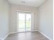 Bright living room featuring light gray walls, wood-look flooring, and sliding glass doors to the outside at 9652 Beckett St, Avon, IN 46123