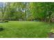 Sprawling green backyard with mature trees, play set, and lush lawn, ideal for recreation and relaxation at 9885 Oakleaf Way, McCordsville, IN 46055