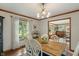 Charming dining room features hardwood floors, a rustic wooden table, and a stylish chandelier at 9885 Oakleaf Way, McCordsville, IN 46055