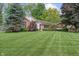 Charming brick and siding home featuring a lush front lawn and mature trees on a sunny day at 9885 Oakleaf Way, McCordsville, IN 46055