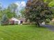 Well-maintained front yard featuring a charming single-story home with mature trees and an expansive lawn at 9885 Oakleaf Way, McCordsville, IN 46055