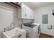 Bright laundry room with white cabinets, utility sink, and modern washer and dryer at 9885 Oakleaf Way, McCordsville, IN 46055