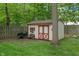Garden shed with red doors and white trim, a charming addition to the outdoor space, perfect for storage at 9885 Oakleaf Way, McCordsville, IN 46055