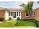 Well-manicured backyard with a brick patio, lush greenery, and manicured bushes at 100 Wellington Rd, Indianapolis, IN 46260