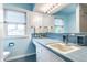 Charming bathroom with a tiled counter, a large mirror, and blue walls at 100 Wellington Rd, Indianapolis, IN 46260