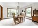 Sunlit dining room with a wood table, six chairs, large windows, and natural light at 100 Wellington Rd, Indianapolis, IN 46260