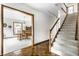 Entryway with light-colored carpeted stairs and a view of the dining room with a wooden table and chairs at 100 Wellington Rd, Indianapolis, IN 46260